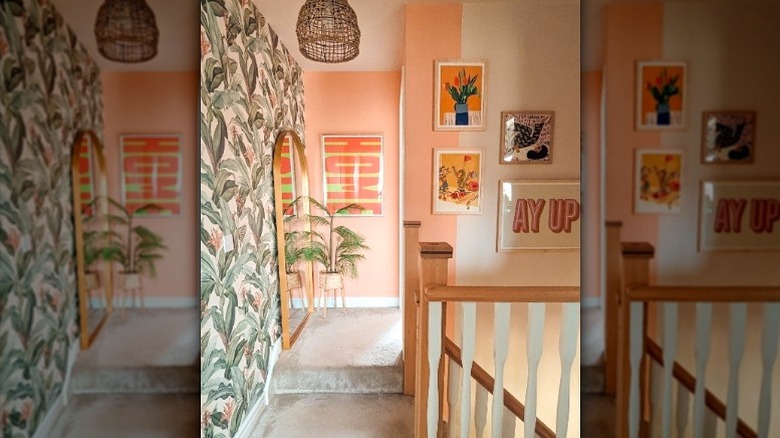 home upstairs landing with botanical wallpaper and orange painted wall extending around corner from small nook