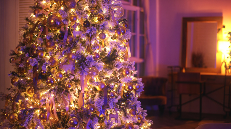 Red ribbon and colorful ornaments on Christmas tree