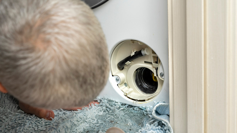 Repairman peeking into filter compartment