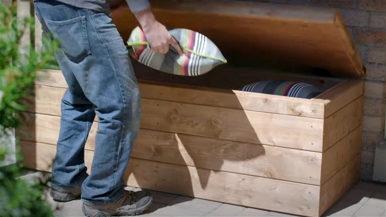 person putting pillow in bench