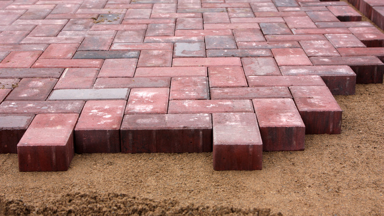 Herringbone pattern patio pavers being installed