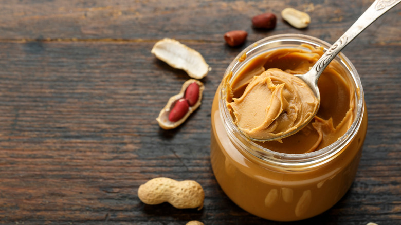 A scoop of peanut butter from jar on a spoon