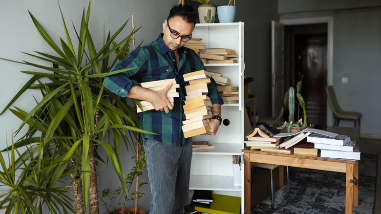 Man holding pile of books