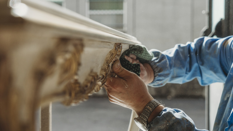 Carpenter polishes wood furniture