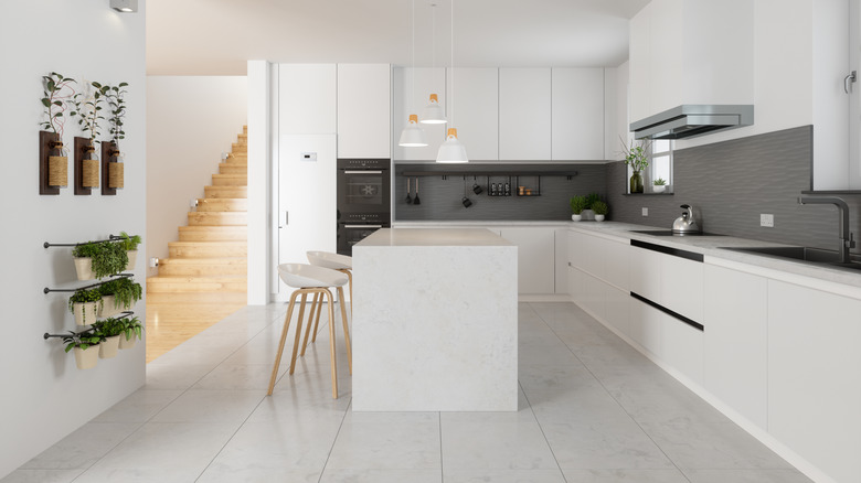 All-white kitchen in home with a view of the staircase