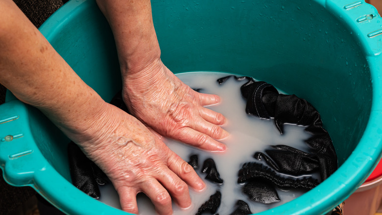 person washing clothes in basin