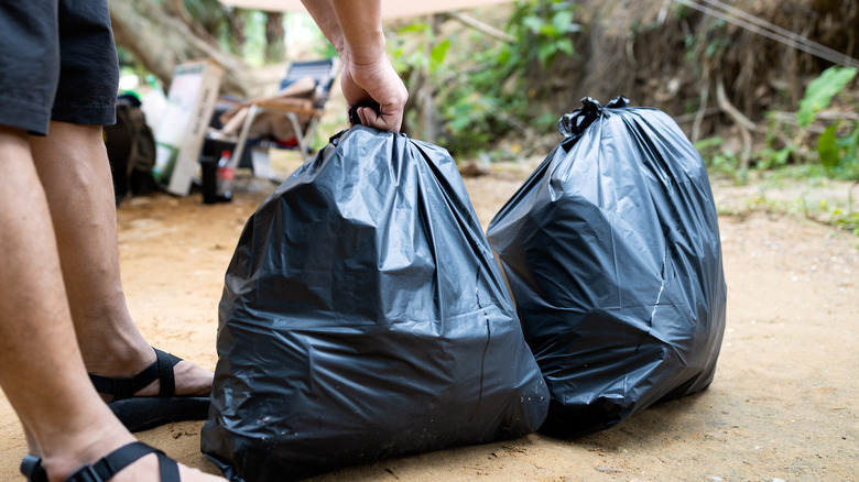 person tying garbage bag