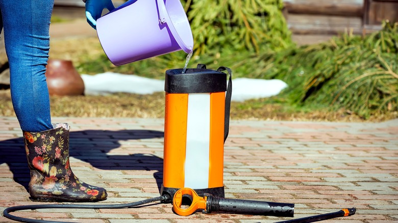 Person pouring mixture into sprayer