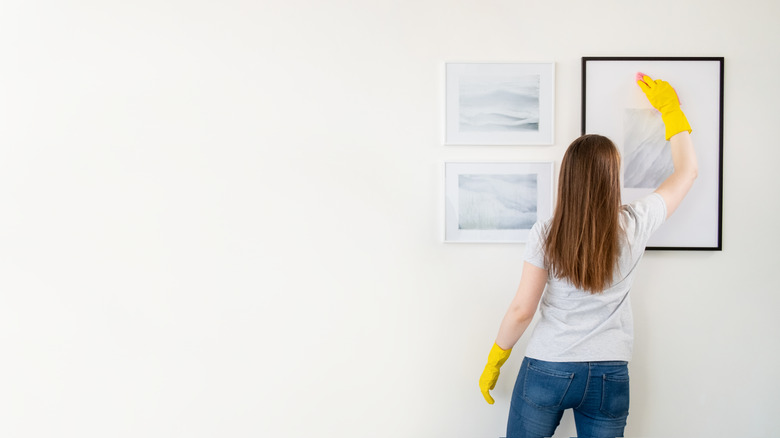 woman cleaning picture frames