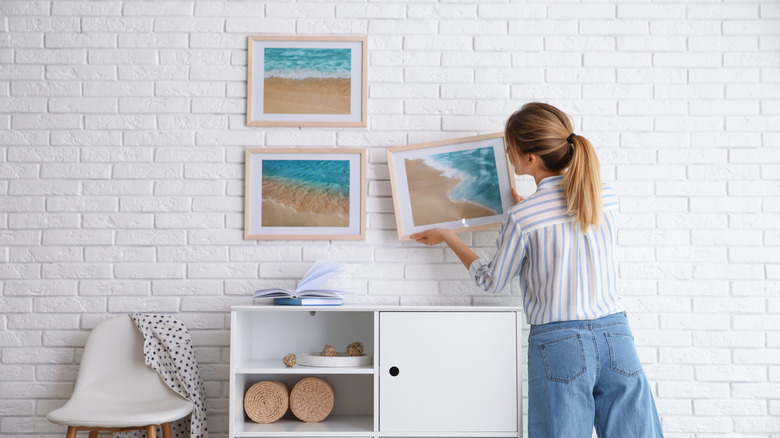 woman hanging picture frames