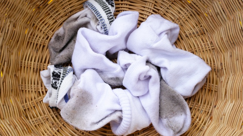 dirty white socks in laundry basket