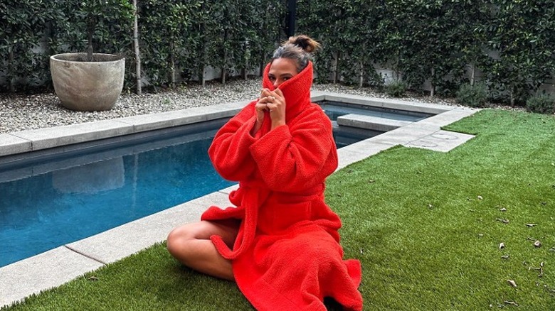 Chrissy Teigen sits on fake grass