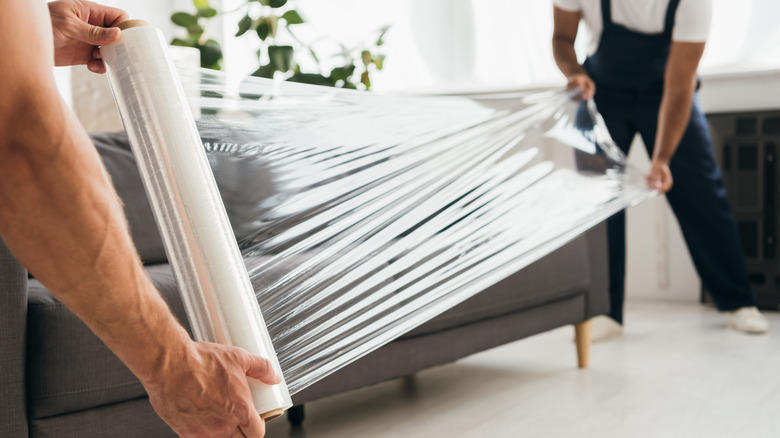 Movers unrolling plastic wrap