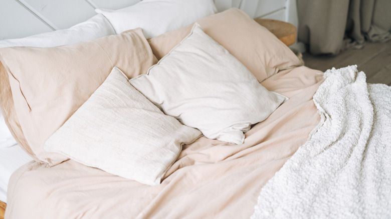 Linen sheets with fluffy throw in white and beige shades