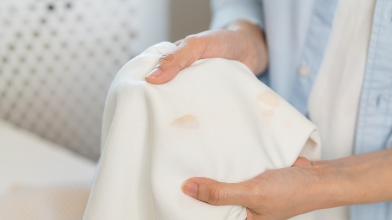 Woman holding white cloth with stain