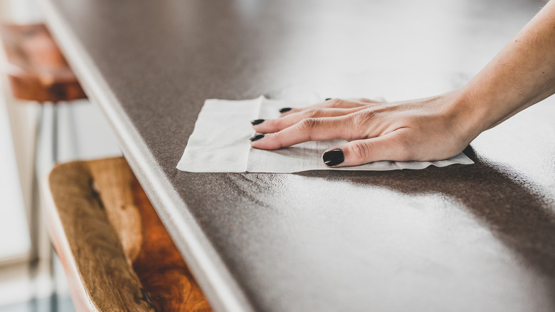 Person wiping surface with disinfecting wipe