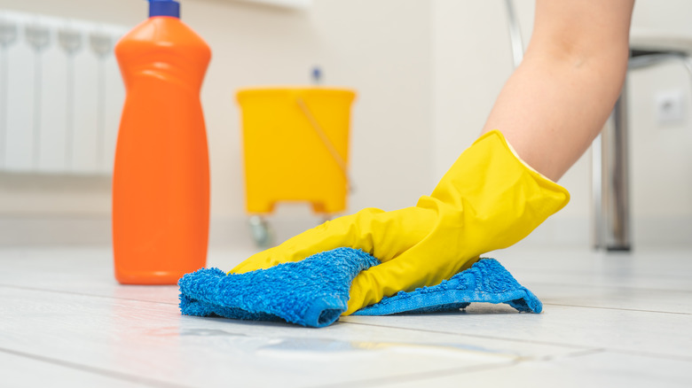 Person cleaning tile floor