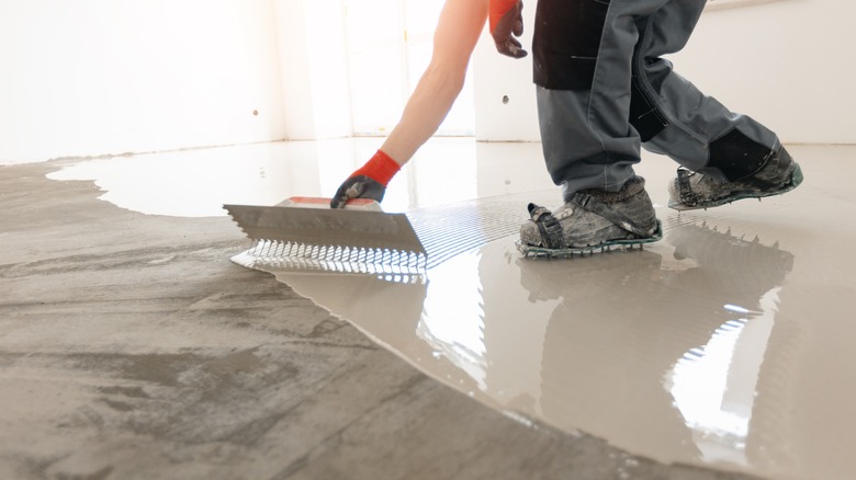 Person spreading a concrete-leveling compound