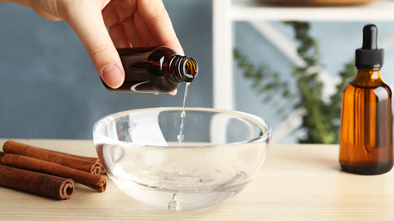 person pouring cinnamon oil