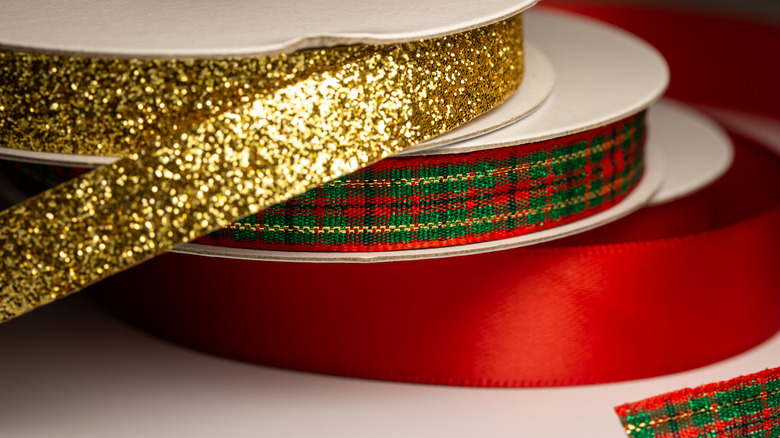 Rolls gold, plaid, and red of Christmas ribbon on spools