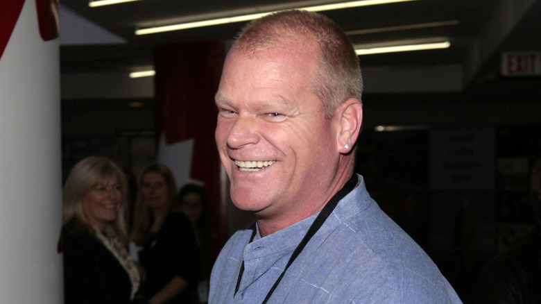 Mike holmes laughing in a blue shirt.