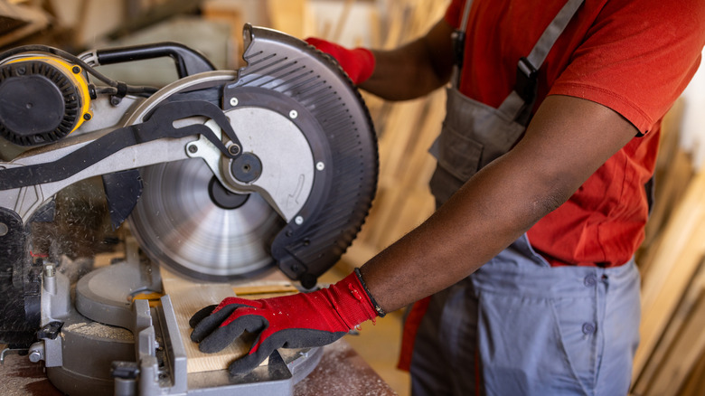 Black man sawing wooden block