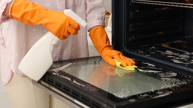 person scrubbing using oven cleaner