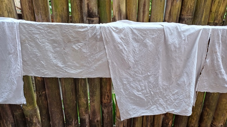 white rags hanging by fence