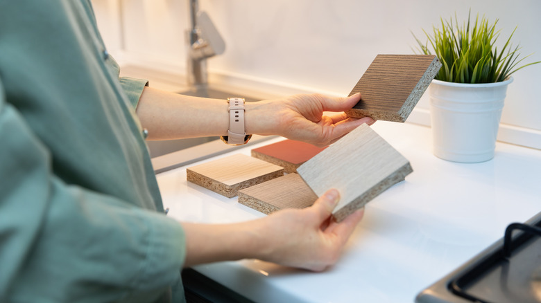 person picking between wood countertop sample