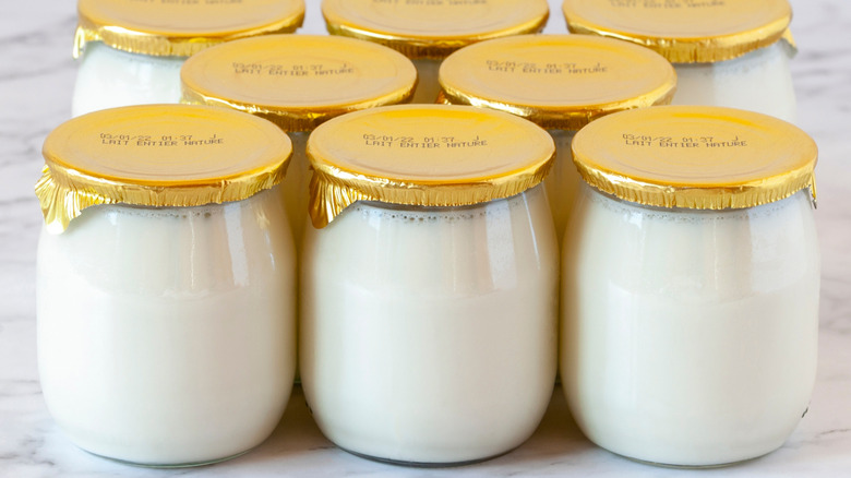 Eight glass yogurt jars with gold lids