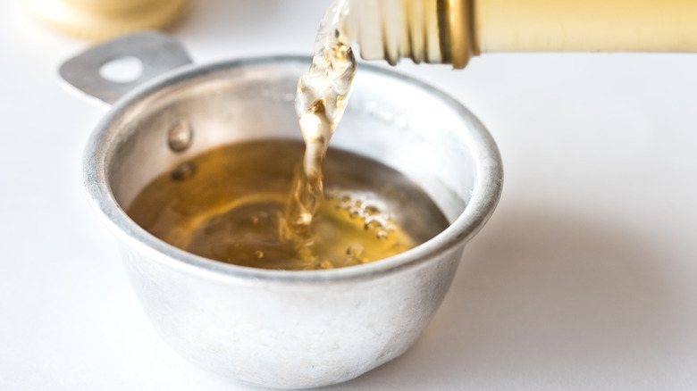 vinegar being poured into a cup