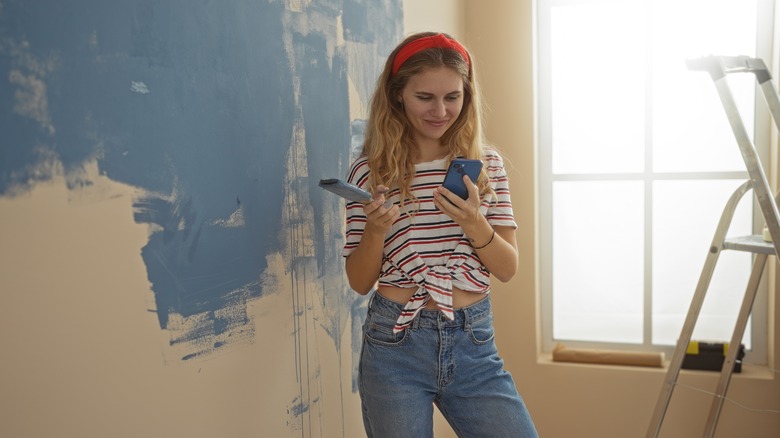 woman painting wall in her home blue