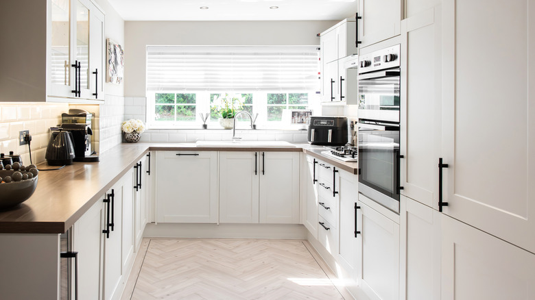 white kitchen with wood floor & countertop