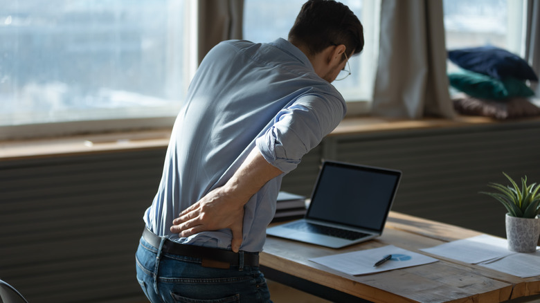 man working at uncomfortable chair