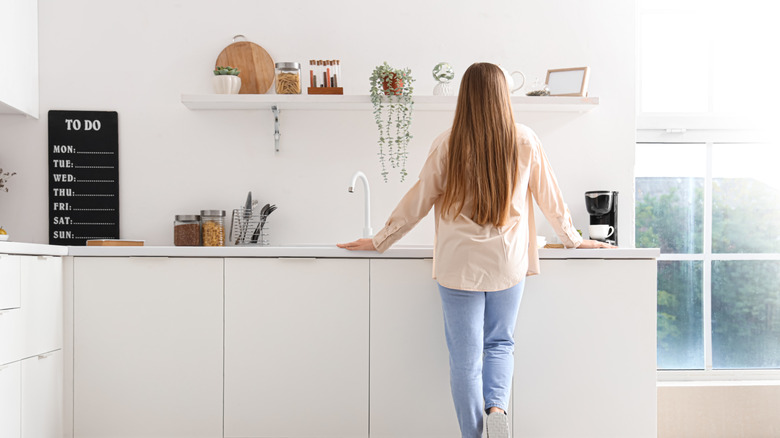 A woman standing over a kitchen counter with chalkboard