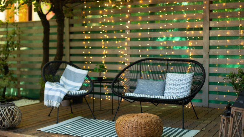 Holiday lights hung behind patio with neutral decor