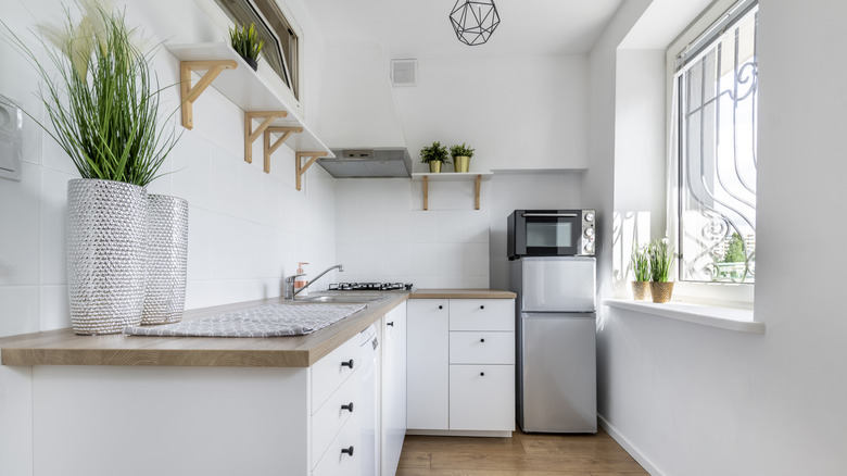 A small kitchen with white cabinets and minimalistic decor