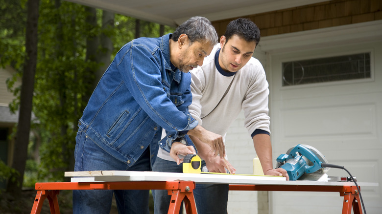 two men cutting wood