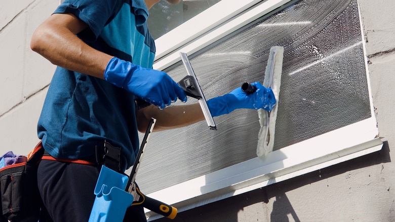 technician cleaning a window