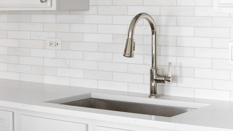 White tile kitchen backsplash behind sink