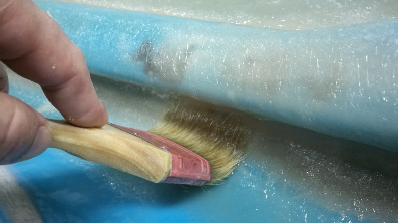 Person painting fiberglass pool