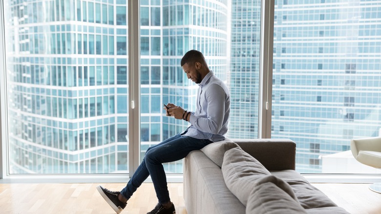 Man holding phone near window