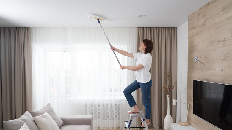 person mopping ceiling