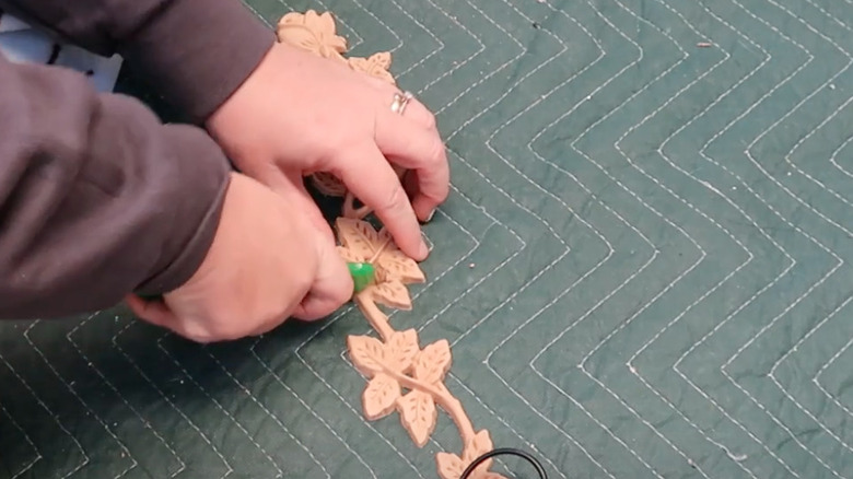 Woman cutting applique with utility knife on green mat