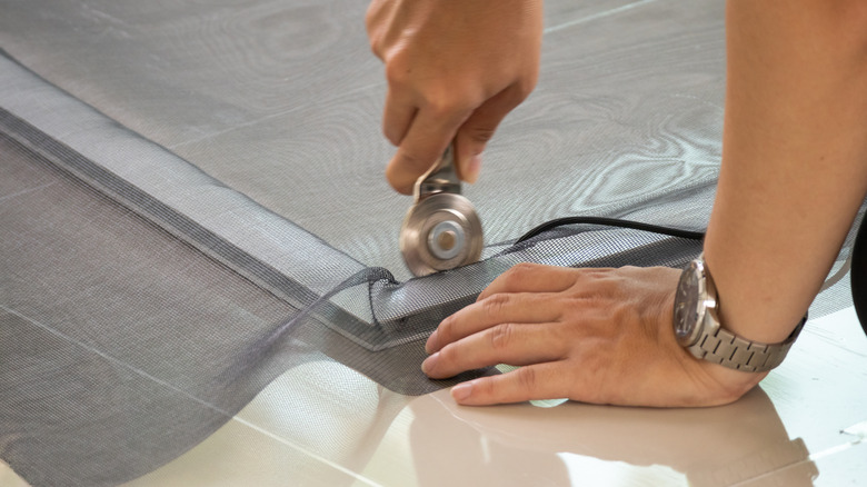 Person installing new window screen