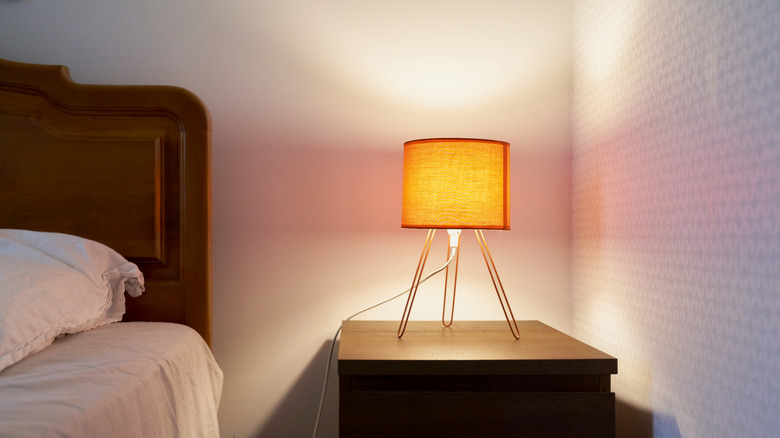 An orange table lamp rests on a nightstand