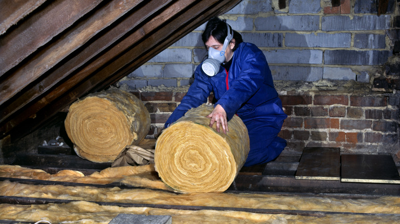 person installing attic insulation