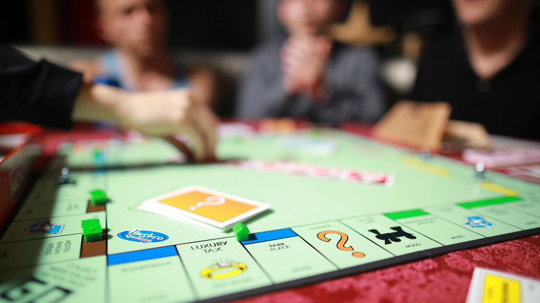 friends playing monopoly board game