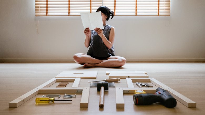 woman reading furniture assembly instructions