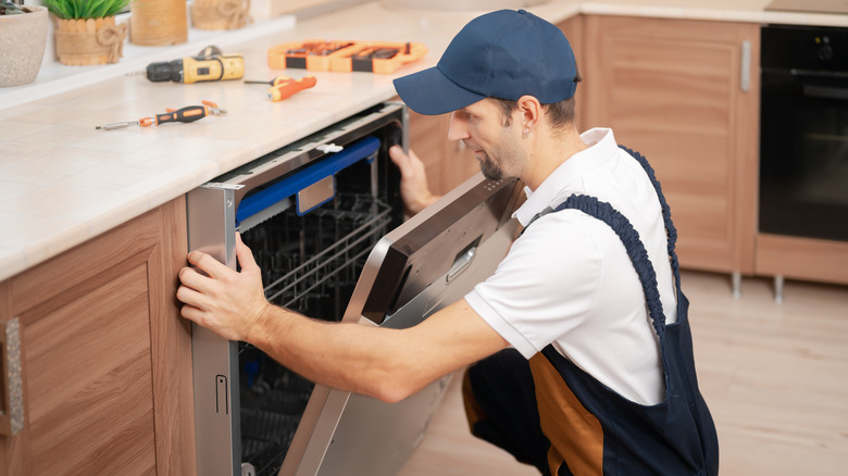 a man fixing a dishwasher